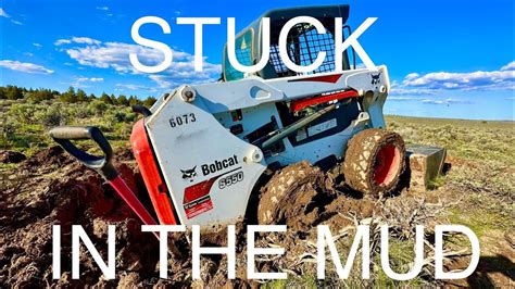 bobcat skid steer stuck in the mud|bob cat kubota stuck in mud.